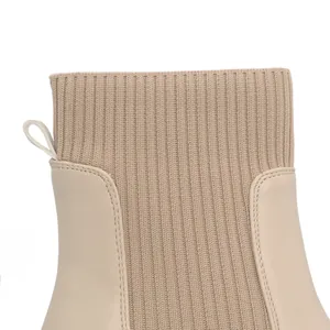 Close-up detail of beige knit and leather ankle boot showing ribbed texture and stitching