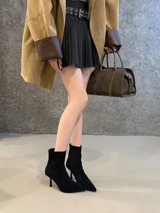 Detail view of black suede pointed toe ankle boots with slim high heels and back zipper.