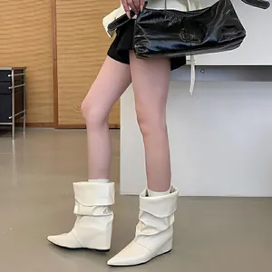 Stylish white pointed toe wedge slouch boots for women in a chic indoor setting