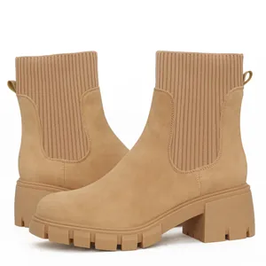 Close-up view of stylish beige Chelsea boots featuring chunky heels and knitted ribbed shafts