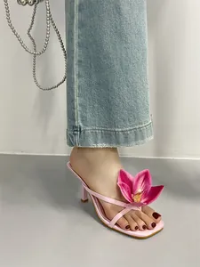 Detailed view of pink square toe sandal featuring a large floral ornament and kitten heel