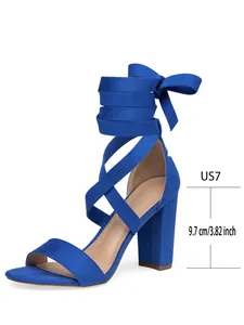 Vista lateral de sandalias de gamuza azul con tacón grueso y diseño de cordones cruzados