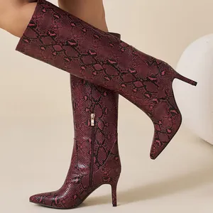 Stylish red snake-skin knee-high boots with pointed toe and sleek stiletto heel