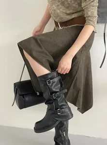 Detailaufnahme schwarzer Western-Halbstiefel mit drei Schnallenriemen an einem Model