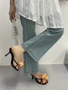 Elegant black square-toe kitten heel sandals featuring vibrant orange orchid flower detail.