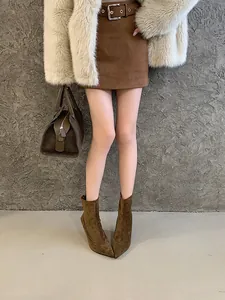 Close-up detail of stylish brown suede pointed-toe ankle boots with slim high heels