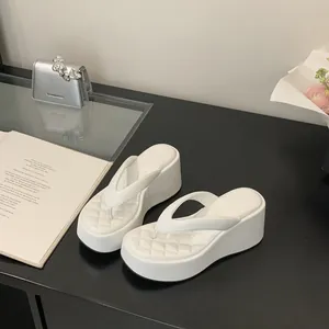 Detail view of stylish white quilted platform wedge flip-flops for summer outfits