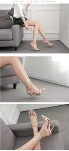 Details von silbernen Stilettos mit spitzer Zehenpartie, Goldketten und Schnürung