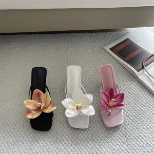 Detailed view of stylish thong sandals with large 3D floral decorations in three chic colors