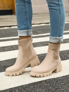 Close-up detail of beige knit Chelsea boots with chunky platform sole on street