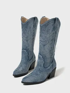 High resolution detail of white embroidery on blue denim western cowboy boots