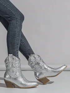 Metallic silver western cowboy boots with embroidered patterns and chunky heels.