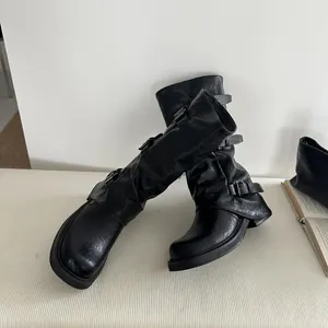 Nahaufnahme der schwarzen Western-Stiefel mit stilvollen Schnallen und lässigem Design.