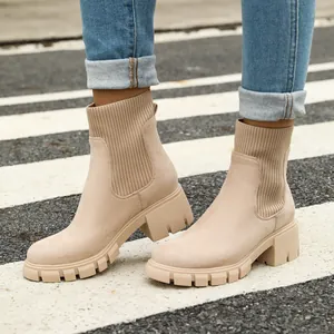 Detail view of beige chunky Chelsea boots with ribbed knit panels and platform sole
