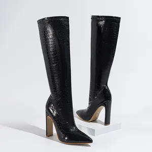 Detail van elegante zwarte kniehoge laarzen met steentextuur en blokhak voor dames.
