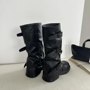 Detailansicht schwarzer mittelhoher Stiefel mit Schnallenriemen und Blockabsatz