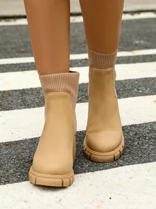 Detailed view of women's beige Chelsea boots with knitted sock collar and chunky platform