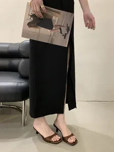 Dettaglio di eleganti sabot marroni a punta quadrata con tacco a spillo in satin.