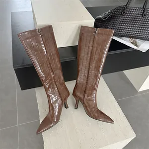 Stylish brown crocodile embossed knee-high boots featuring pointed toe and elegant stiletto heel.