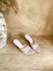 Dettaglio di sandali con zeppa in pelle scamosciata rosa e borchie argentate moda