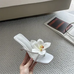 Close-up detail of white French style thong sandal with 3D flower decoration