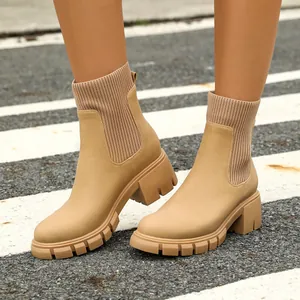 Detailed macro view of women's beige chunky Chelsea boots with elastic knit cuffs.