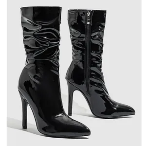Detailed side view of black patent leather slouchy boots with thin stiletto heels.