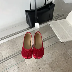 Top view of red satin split-toe Tabi ballet flats with decorative bow details