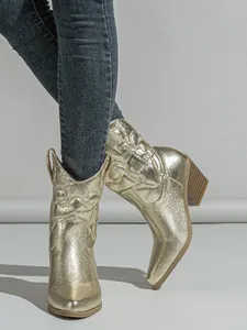 Detailed view of metallic gold Western cowboy boots featuring embroidered floral patterns.