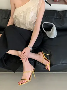 Élégantes sandales à talons aiguilles dorées avec fines brides dans un décor de style chic