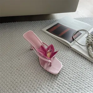 Detailed view of elegant pink high-heeled thong sandal with a 3D flower ornament