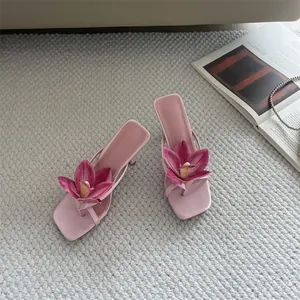 Top view of elegant pink high heel thong sandals with decorative large orchid flower