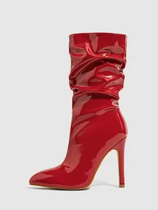 Close-up detail of red patent leather slouchy mid-calf boots with stiletto heels