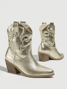 Detailed view of metallic gold cowboy boots featuring intricate embroidery and block heel