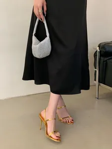 Sandales à talons aiguilles dorées métallisées avec design à bride minimaliste.