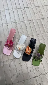 Top down view of elegant high-heeled thong sandals with 3D orchid flower details.