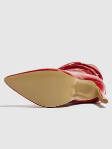 Bottom view of a vibrant red patent leather stiletto boot with a pointed toe