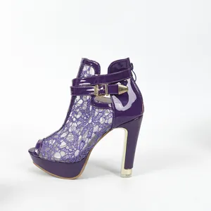 Détail de sandales à plateforme en dentelle violette avec bout ouvert et boucle dorée
