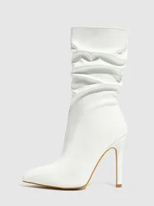 Side profile of white patent leather stiletto boots featuring a stylish slouched design.