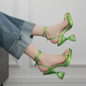 Detail van metallic groene plateau sandalen met een unieke zandlopervormige hak