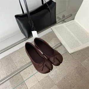 Detail view showing the unique split-toe and bow on these dark brown Tabi flats