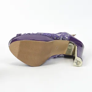 Vue détaillée de la semelle et du talon doré d'une sandale plateforme en dentelle violette