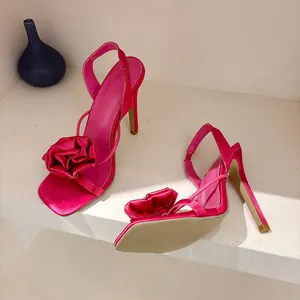 Detailed shot of fuchsia satin high heel sandals with rose flower accent and ankle strap