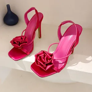 Detail view of hot pink silk sandals with a large handmade fabric rose decoration