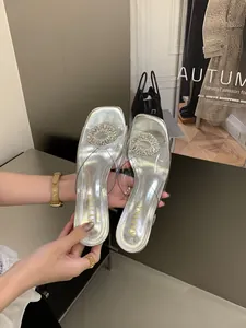 Detailed view of silver PVC transparent sandals with a sparkling rhinestone buckle