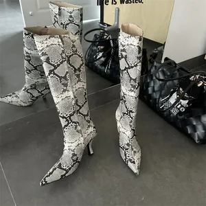 Detail of snakeskin pattern knee-high boots with stiletto heel and pointed toe.