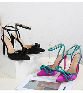 Close-up detail of stylish bow-decorated pointed-toe stiletto high heels in satin