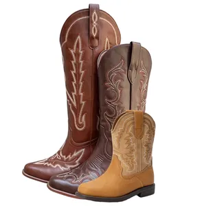 Three different sizes of brown western cowboy boots with classic decorative embroidery details