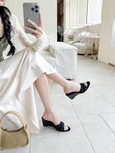 Eleganti sandali neri con zeppa e borchie argentate indossati da una modella.