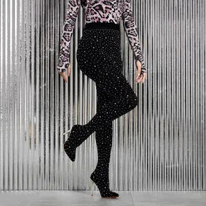 Close-up of sparkling rhinestone-encrusted stiletto pants boots against a metallic wall